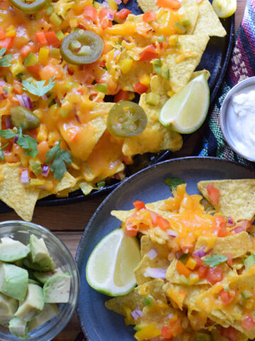 a-platter-of-vegetable-and-cheese-nachos-image Loaded veggie nachos on a platter and a serving plate.