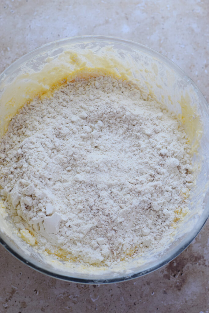 Adding dry ingredients to muffin batter.