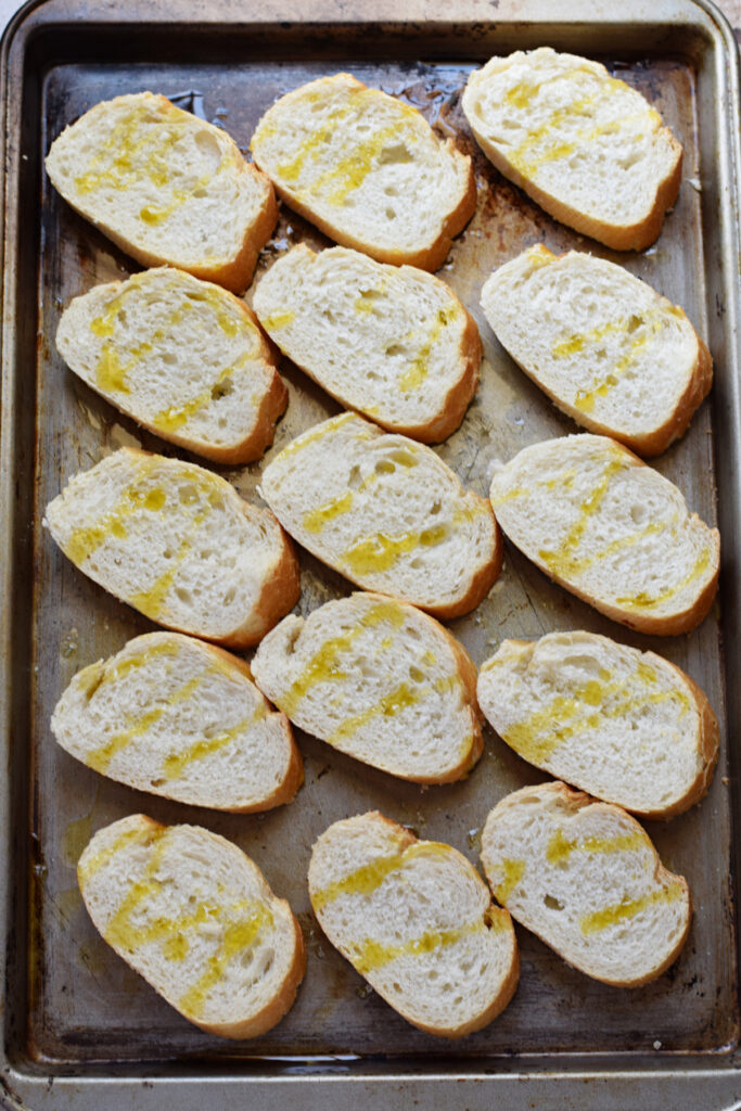 Baguette slices on a baking tray.