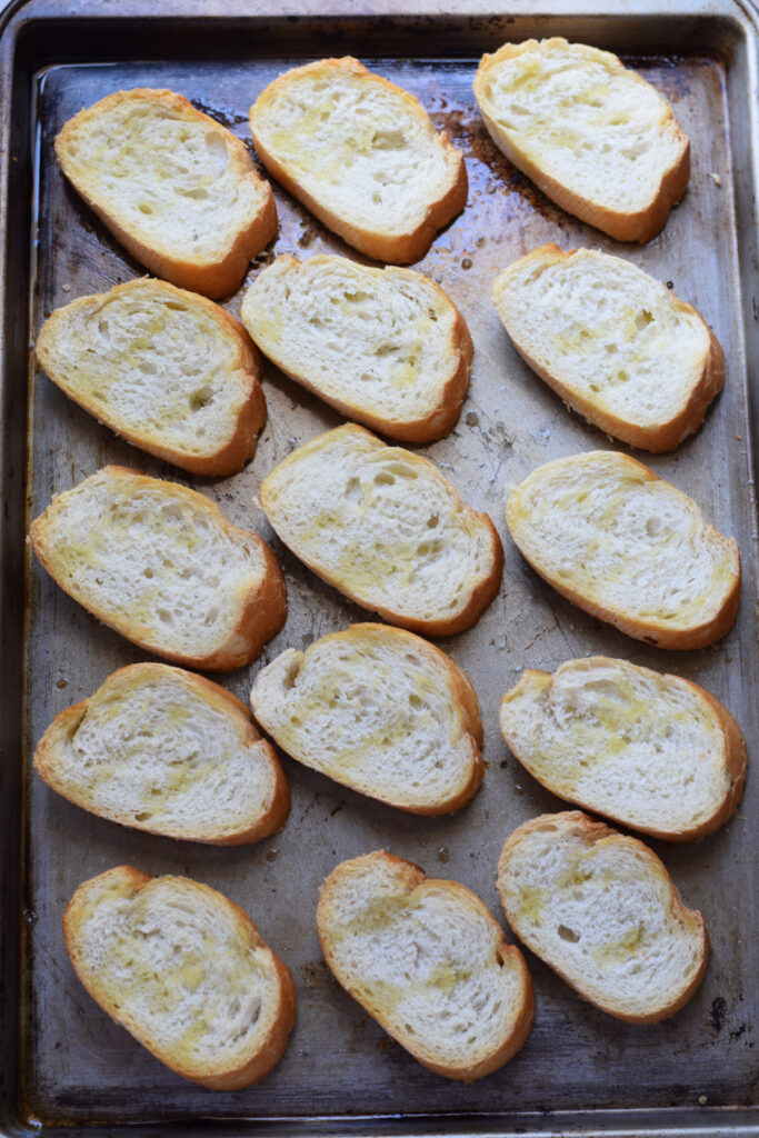 Baked baguette slices on a baking tray.