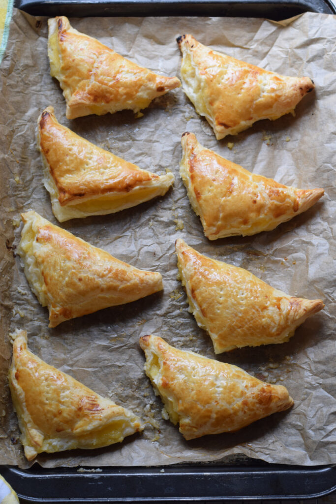 Baked lemon turnovers on a baking tray.