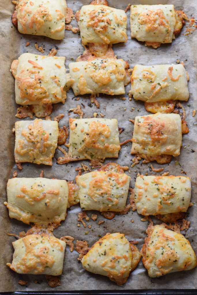 Baked pizza bites on a baking tray.