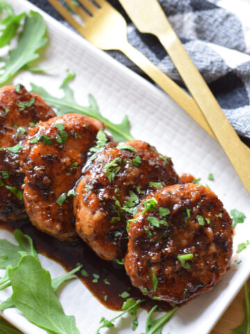Pork medallions on a white plate.