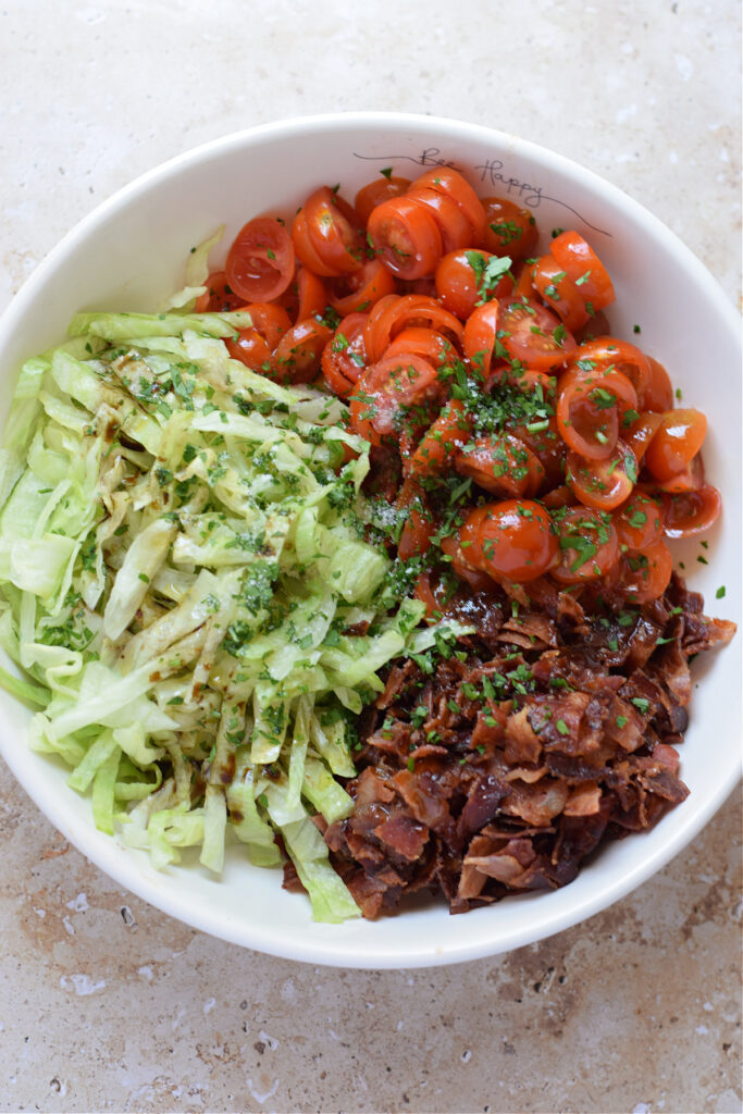 Making a blt salad in a bowl.