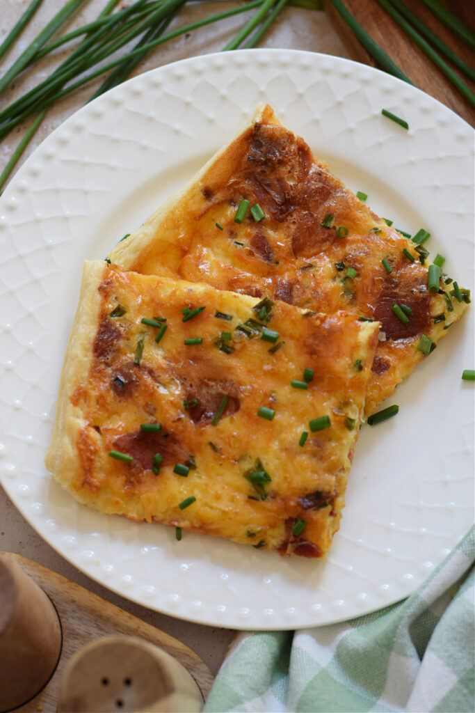 Close up of puff pastry breakfast quiche on a plate.