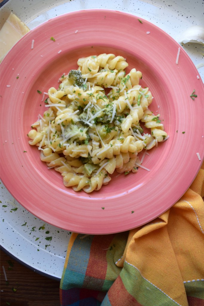 20 Minute Parmesan Pasta with Broccoli in a pink pasta bowl with a tea towel