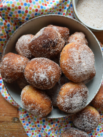 Mexican Doughnuts in a bowl with cinnamon sugar.
