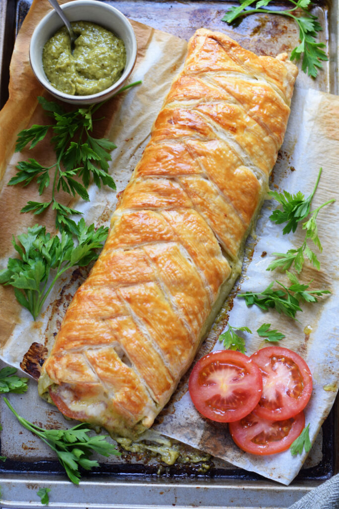 Pastry braid on a tray with tomatoes and pesto.