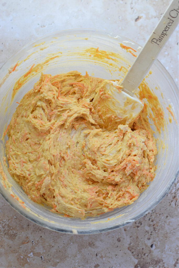 Carrot muffin batter in a glass bowl.