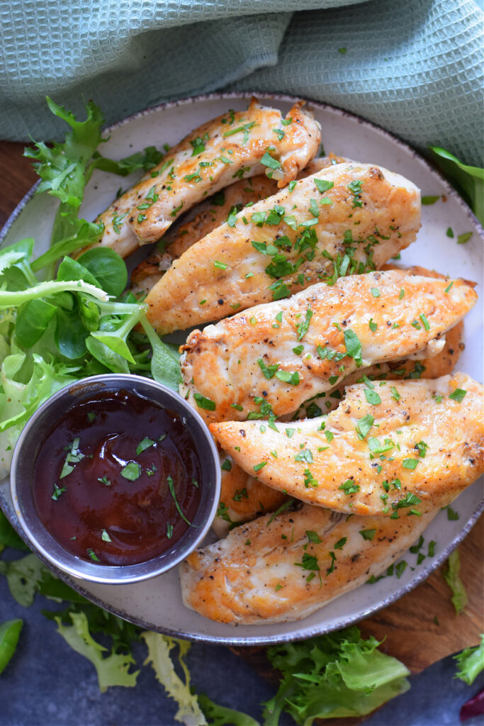 chicken tenders on a plate with dip.