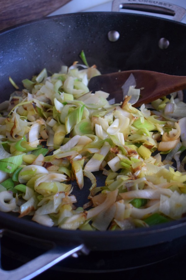 Cooking leeks in a skillet.