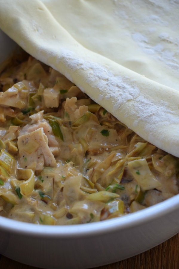 Cover a chicken pie with puff pastry.