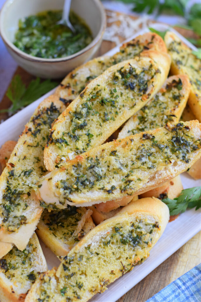 Close up of garlic parmesan crostini on a white plate.