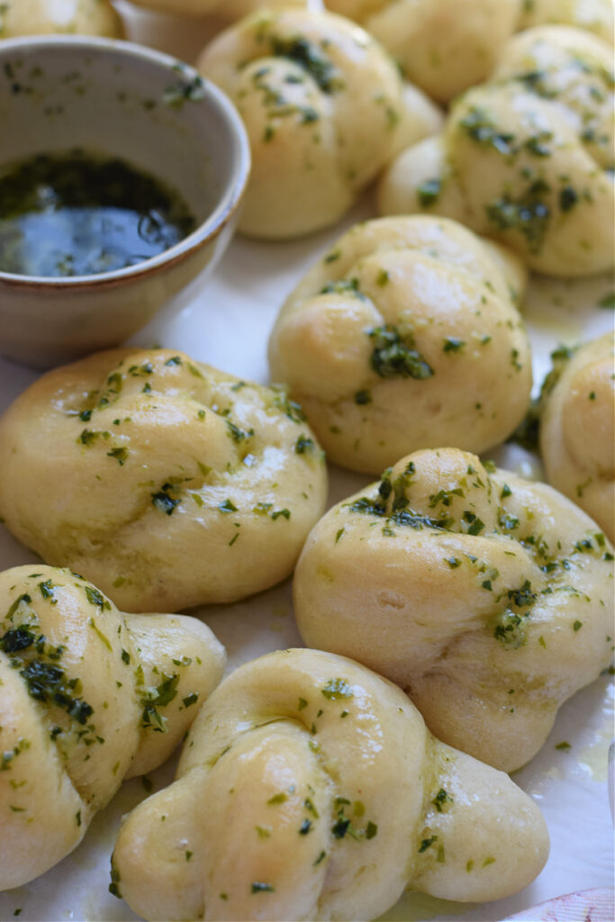 Garlic knots on a tray with fresh parsley.
