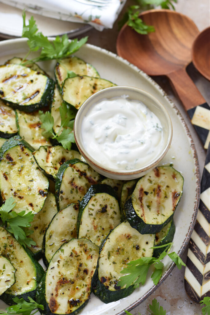Zucchini on a serving platter with a dip.