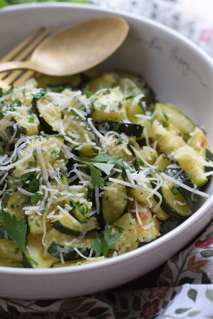 Close up of zucchini in a bowl with parmesan cheese.