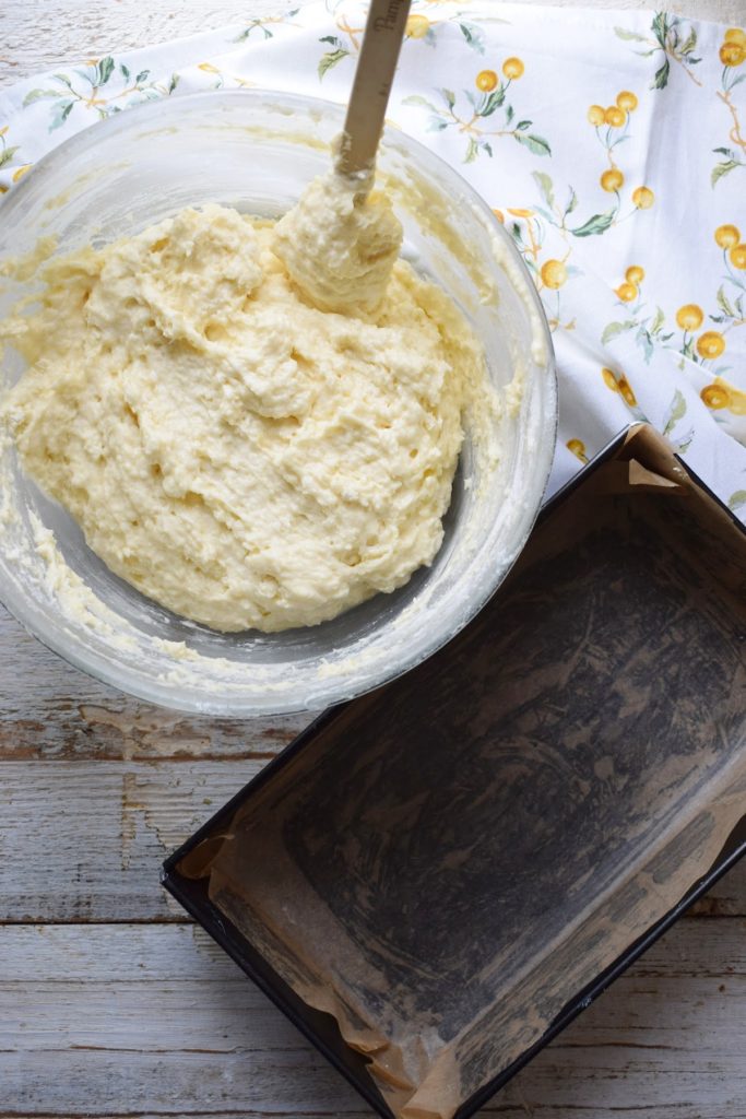 Batter in a bowl and a prepared loaf tin.