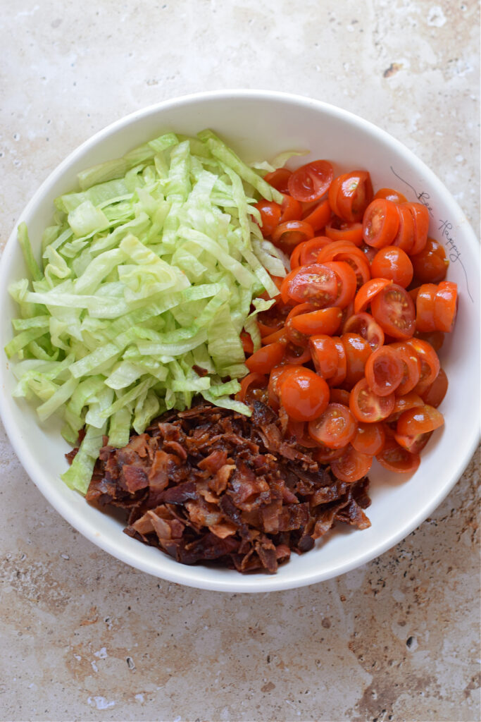 Making a blt salad in a bowl.