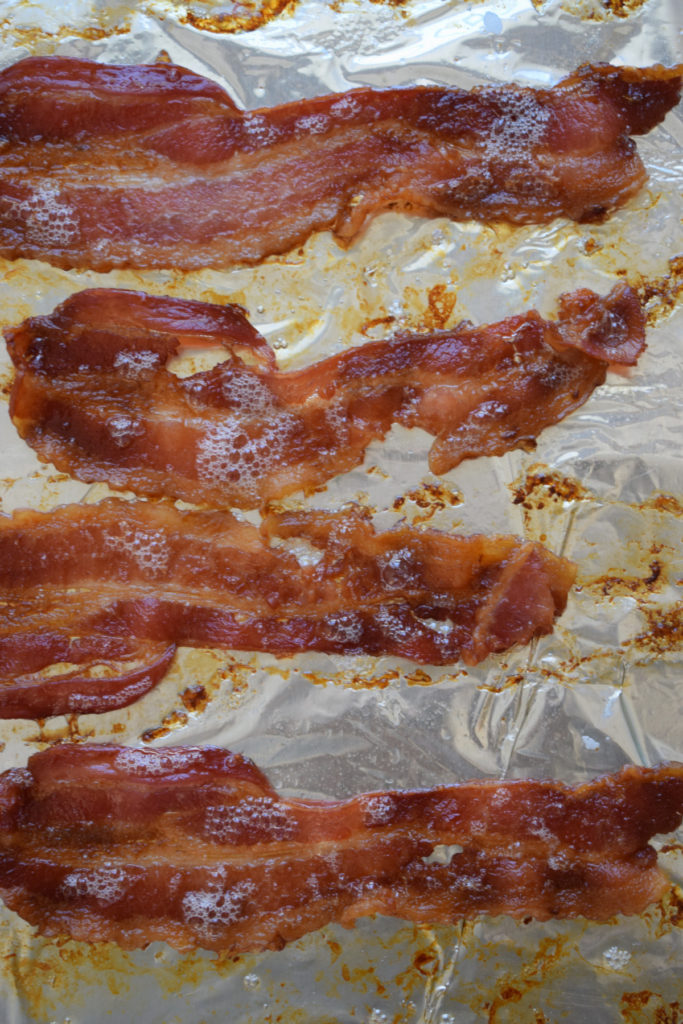 Cooked bacon on a baking tray.