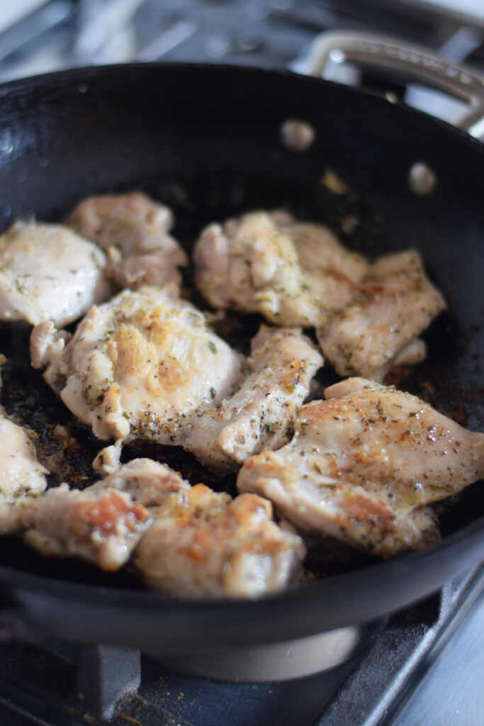Browning chicken in a skillet.