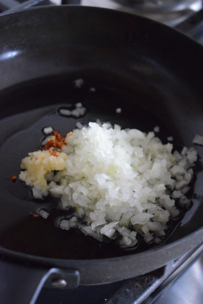 Cooking onions and garlic in a frying pan.