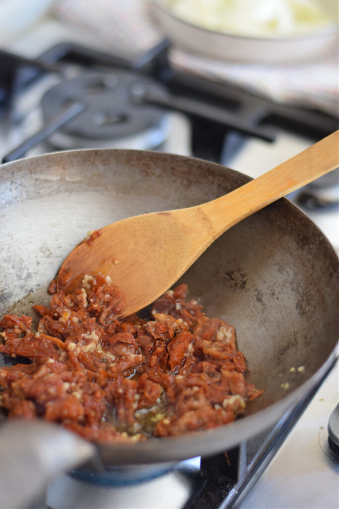 Cooking sun dried tomatoes in a wok.