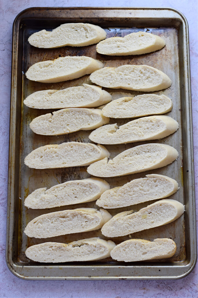Baguette slices on a baking tray.