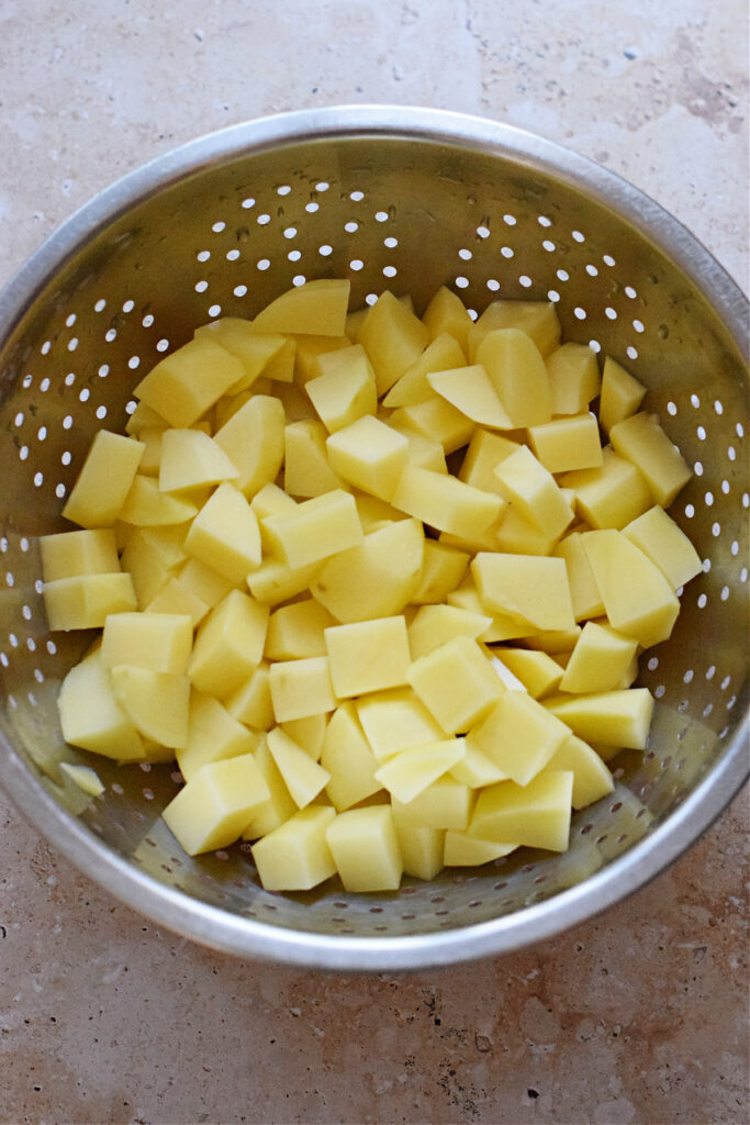 Cut potatoes in a colander.