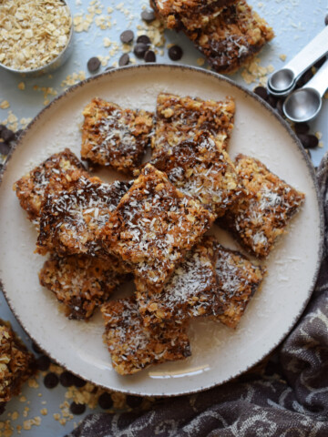 Chocoalte Dulce de Leche bars on a plate with a blue background.