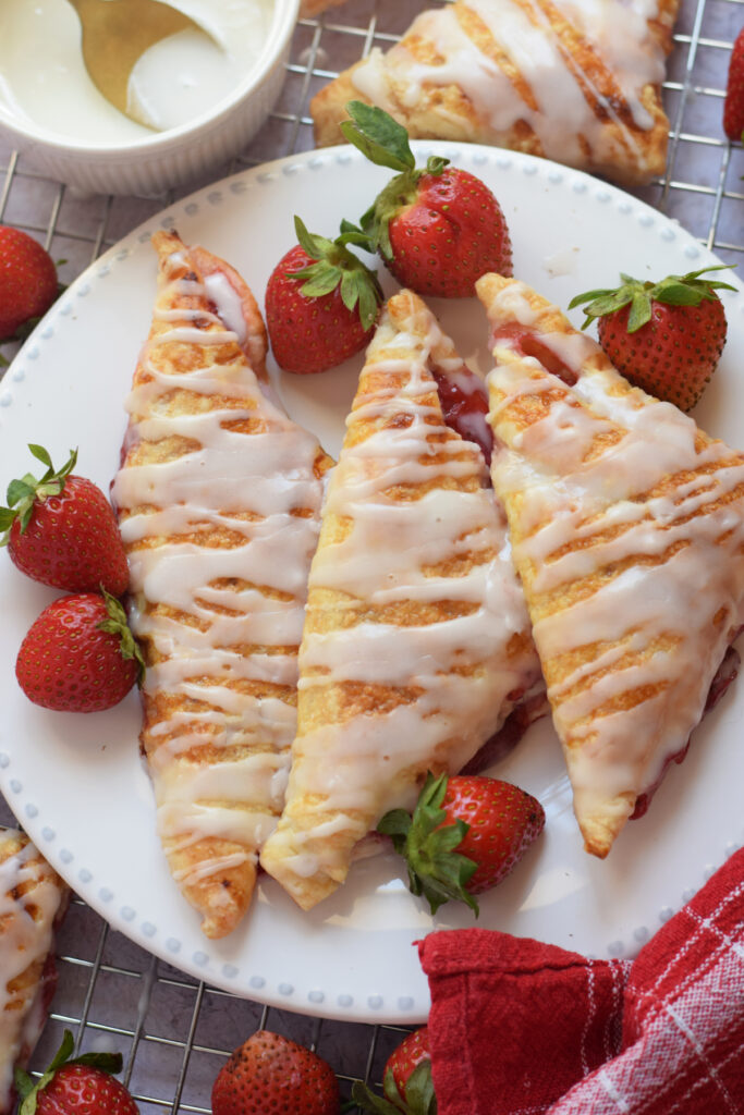Turnovers filled with strawberries on a white plate.