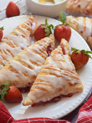 Close up of puff pastry turnovers on a white plate.