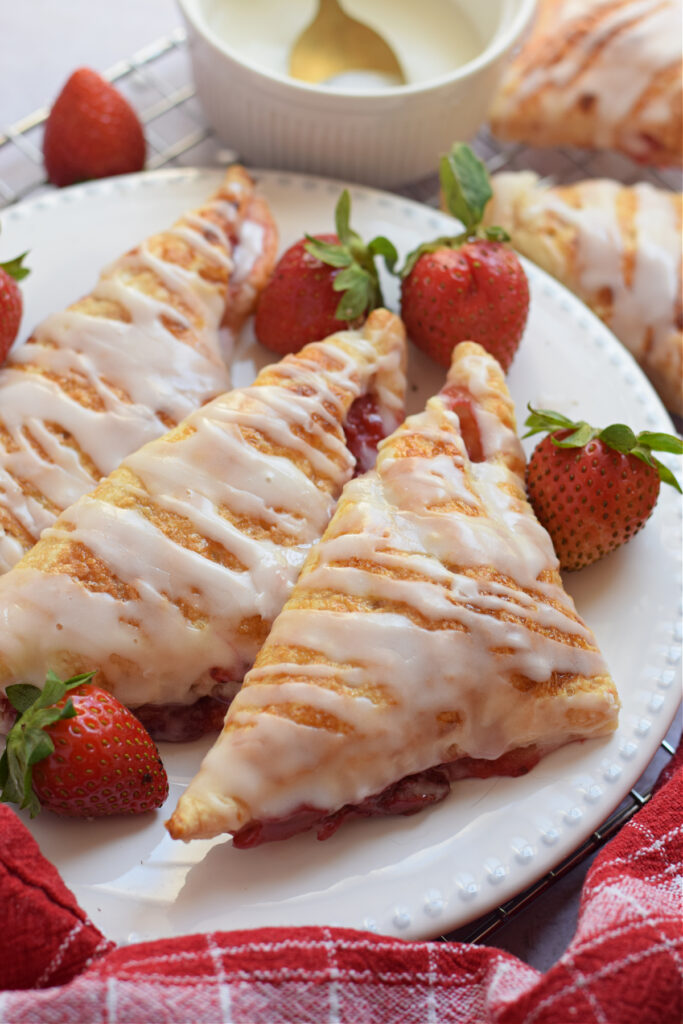 Close up of puff pastry turnovers on a white plate.