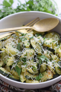 Parmesan topped zucchini in a white bowl.