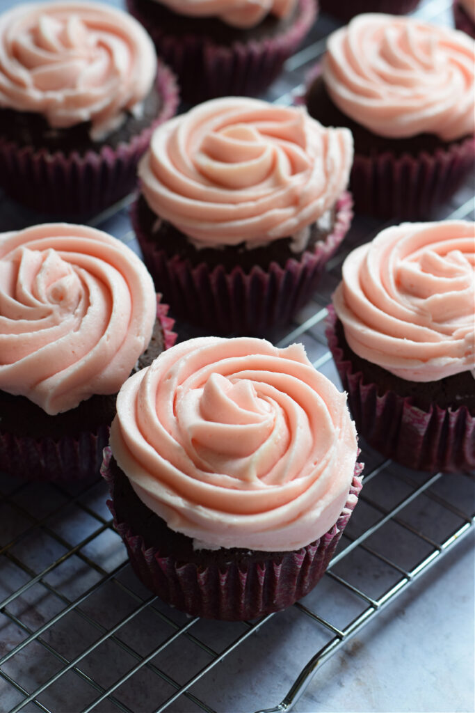 Frosted cupcakes on a cooling rack.