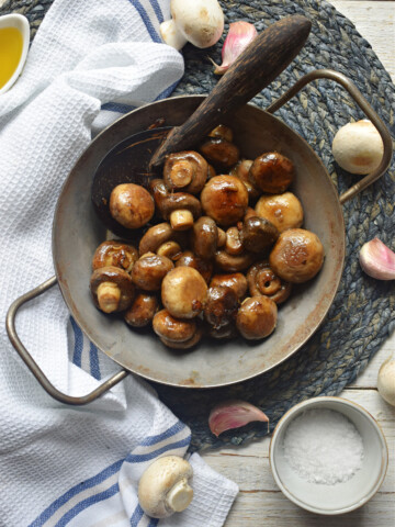 over head veiw of the garlic mushrooms with a tea towel
