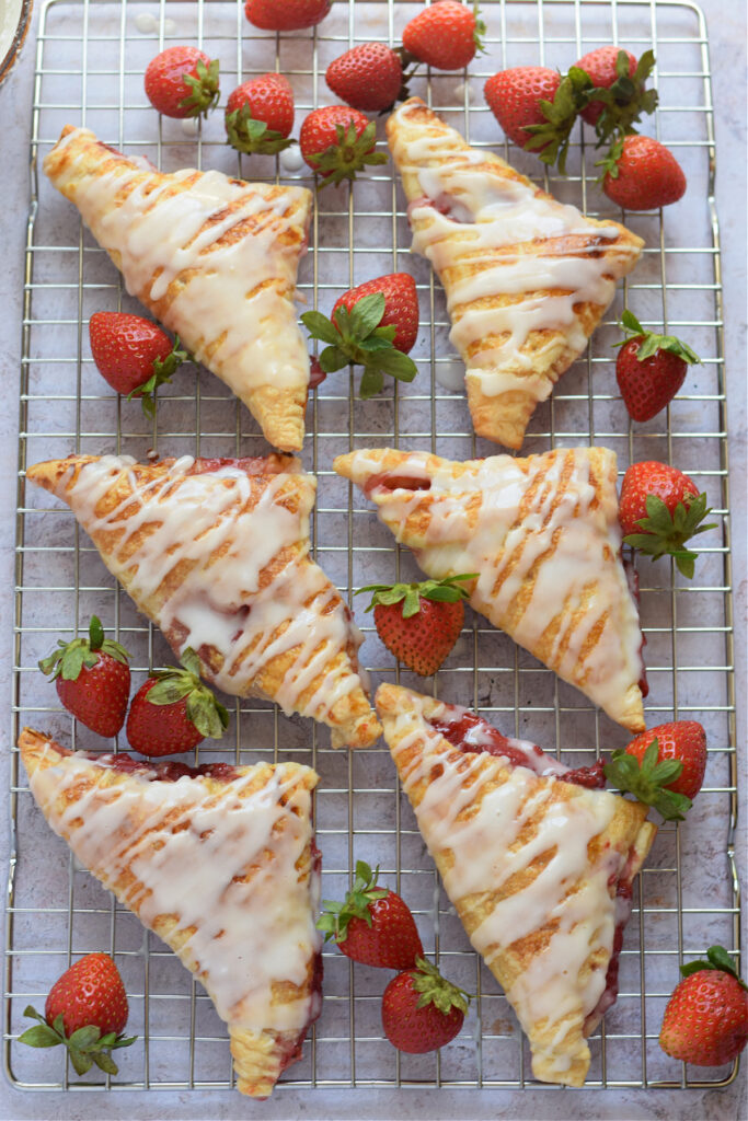Glazed puff pastry turnovers on a tray.