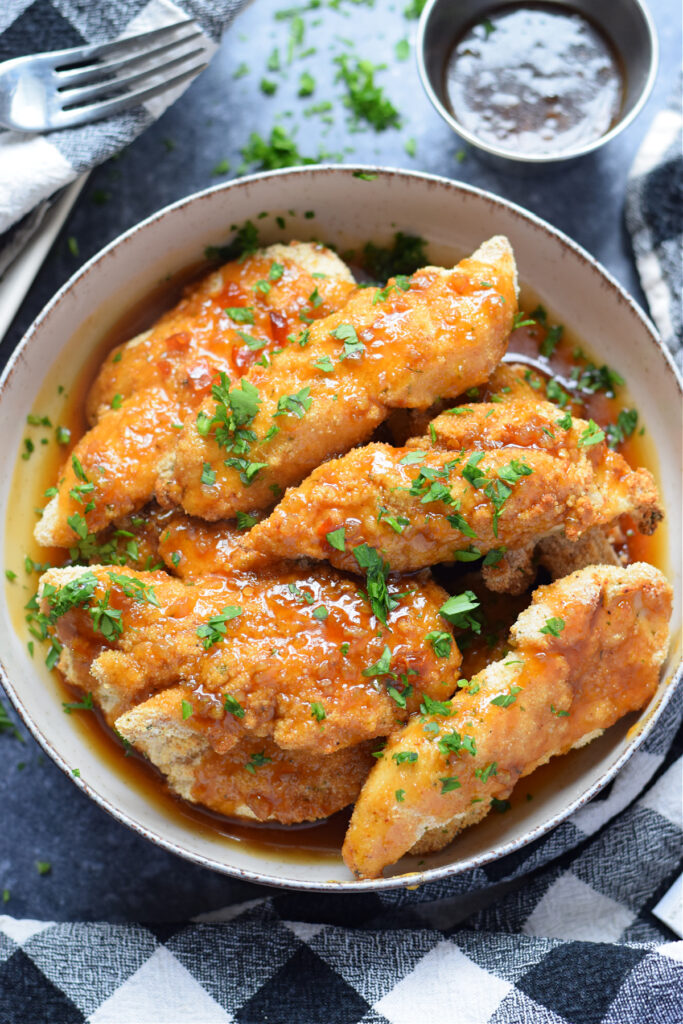 Honey garlic chicken tenders in a bowl.