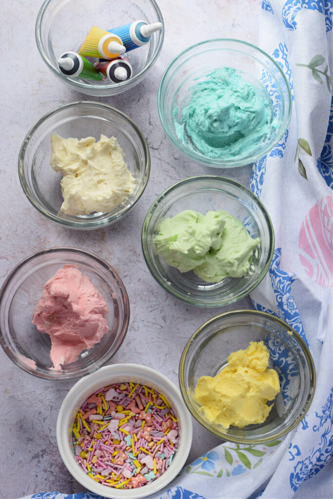 Coloured frosting in small bowl.