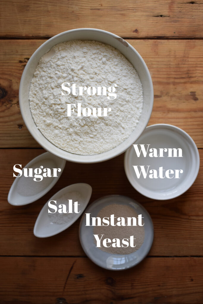 Ingredients to make baguette bread on a wooden board.