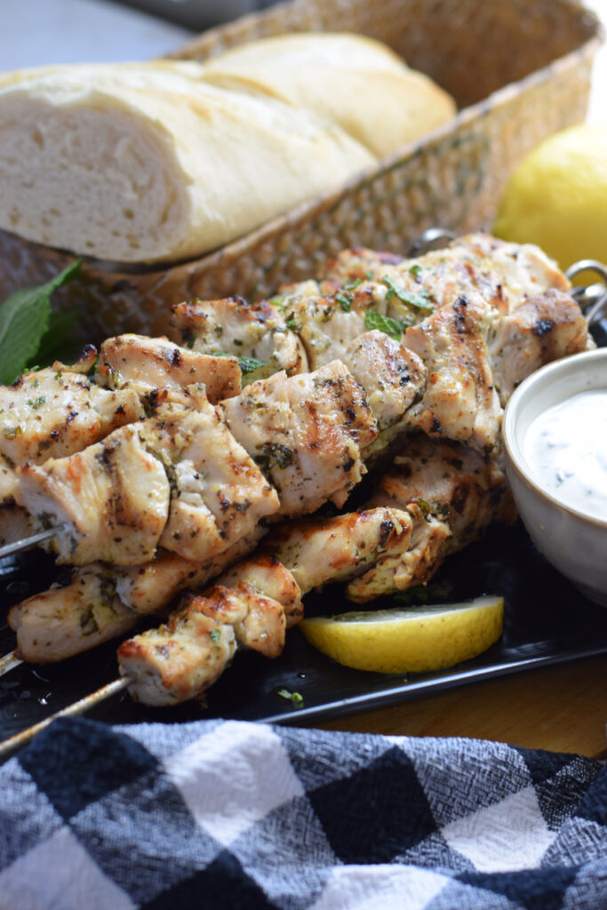 Chicken skewers on a plate with lemon.