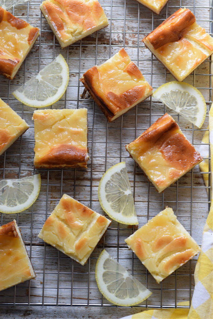 lemon-cheesecake-bars-on-a-baking-tray-image Lemon cheesecake bars on a rack.