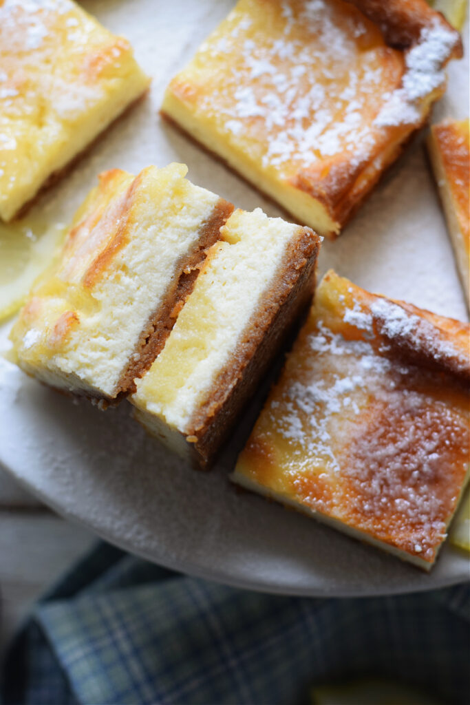 Lemon cheesecake bars on a serving plate.