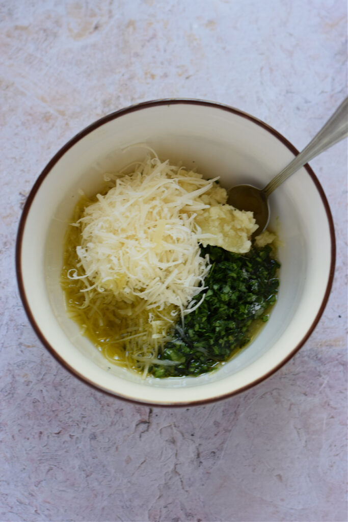 making a garlic parmesan topping in a small bowl.