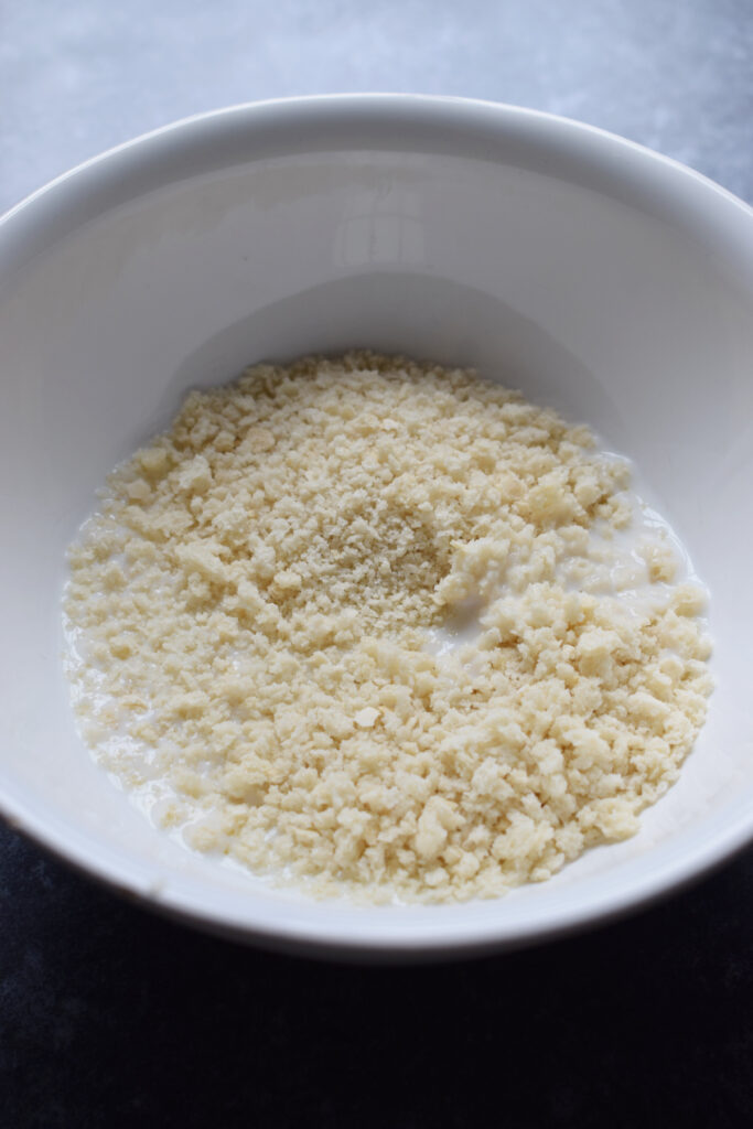 Mixing bread crumbs and milk in a bowl.