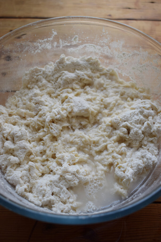 Adding water to bread dough.