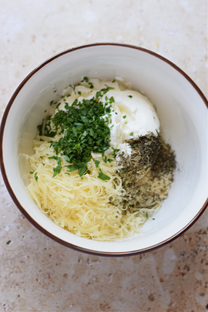 Making a herb cream cheese in a bowl.