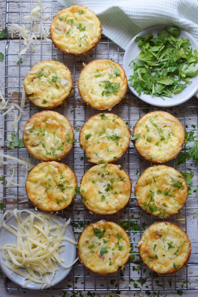 Cheddar mini quiche on a baking rack with cheese.