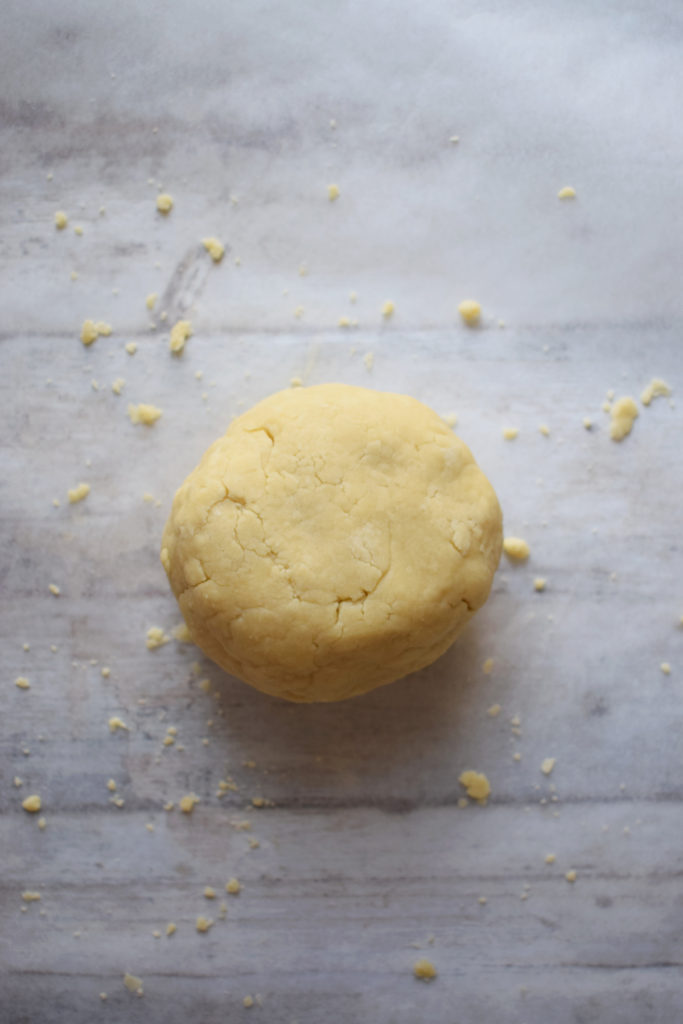 A ball of pastry on a sheet of parchment paper.