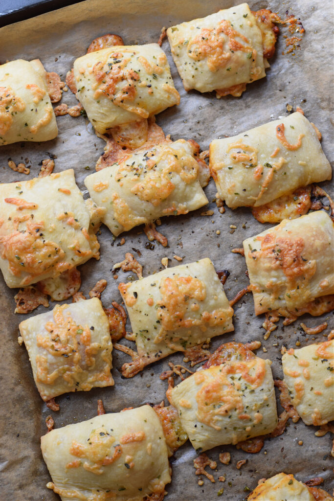 Pizza pocket bites on a baking tray.
