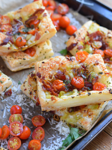 puff-pastry-leek-tomato-bacon-tarts-image Puff pastry tomato and bacon tarts on a tray.
